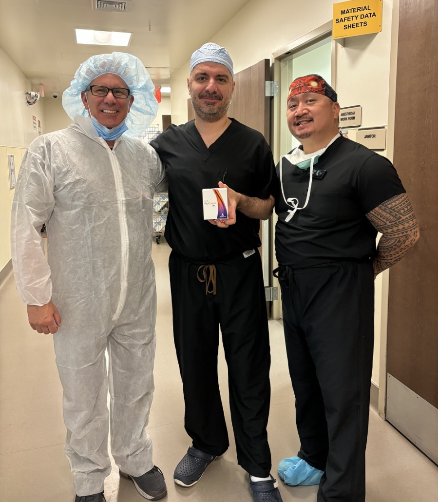 Dr. standing next to two colleagues in a surgical setting.